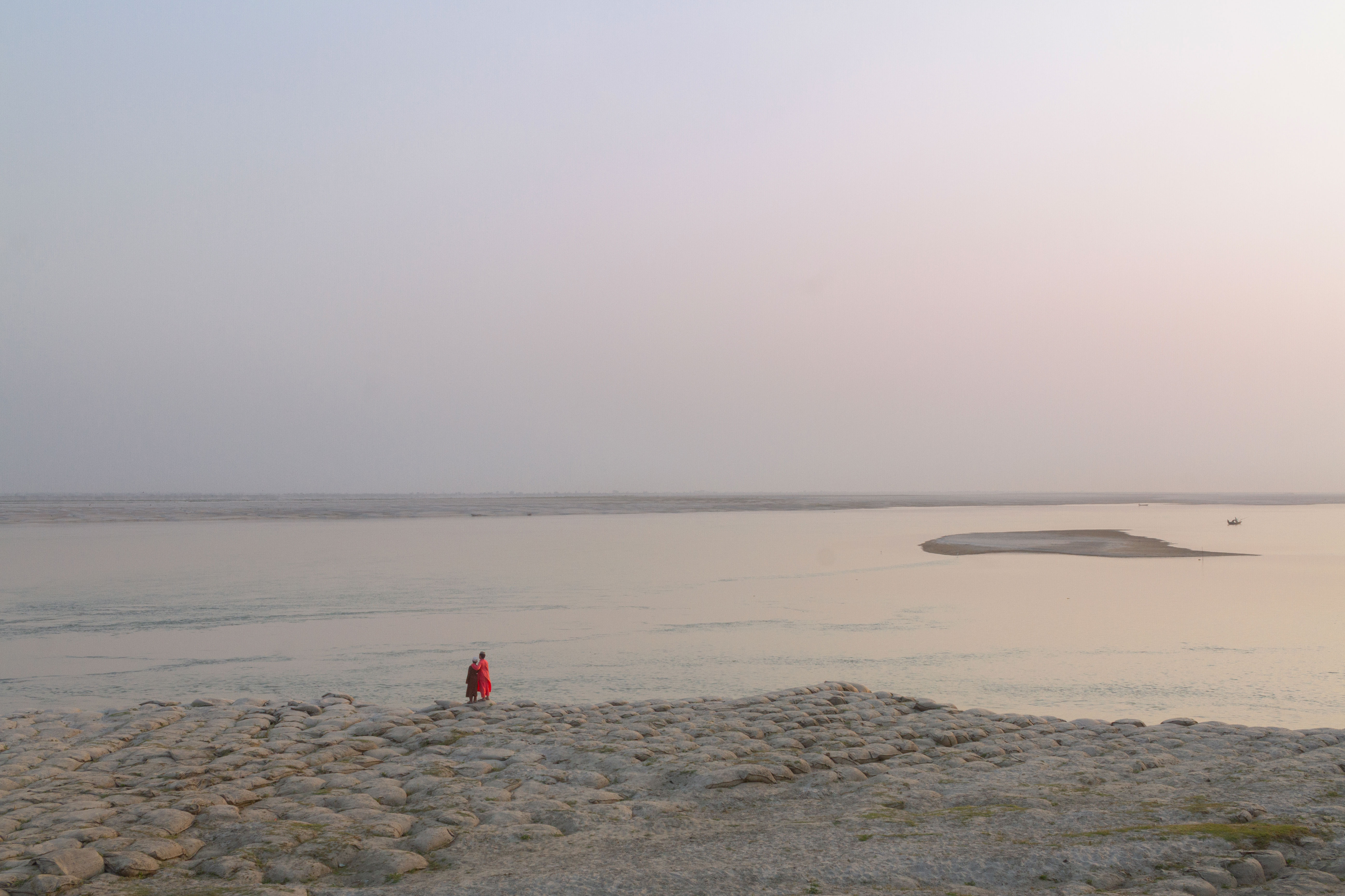 Standing by the river, where lost moments ripple away—observing the tide, searching for a sense of belonging.