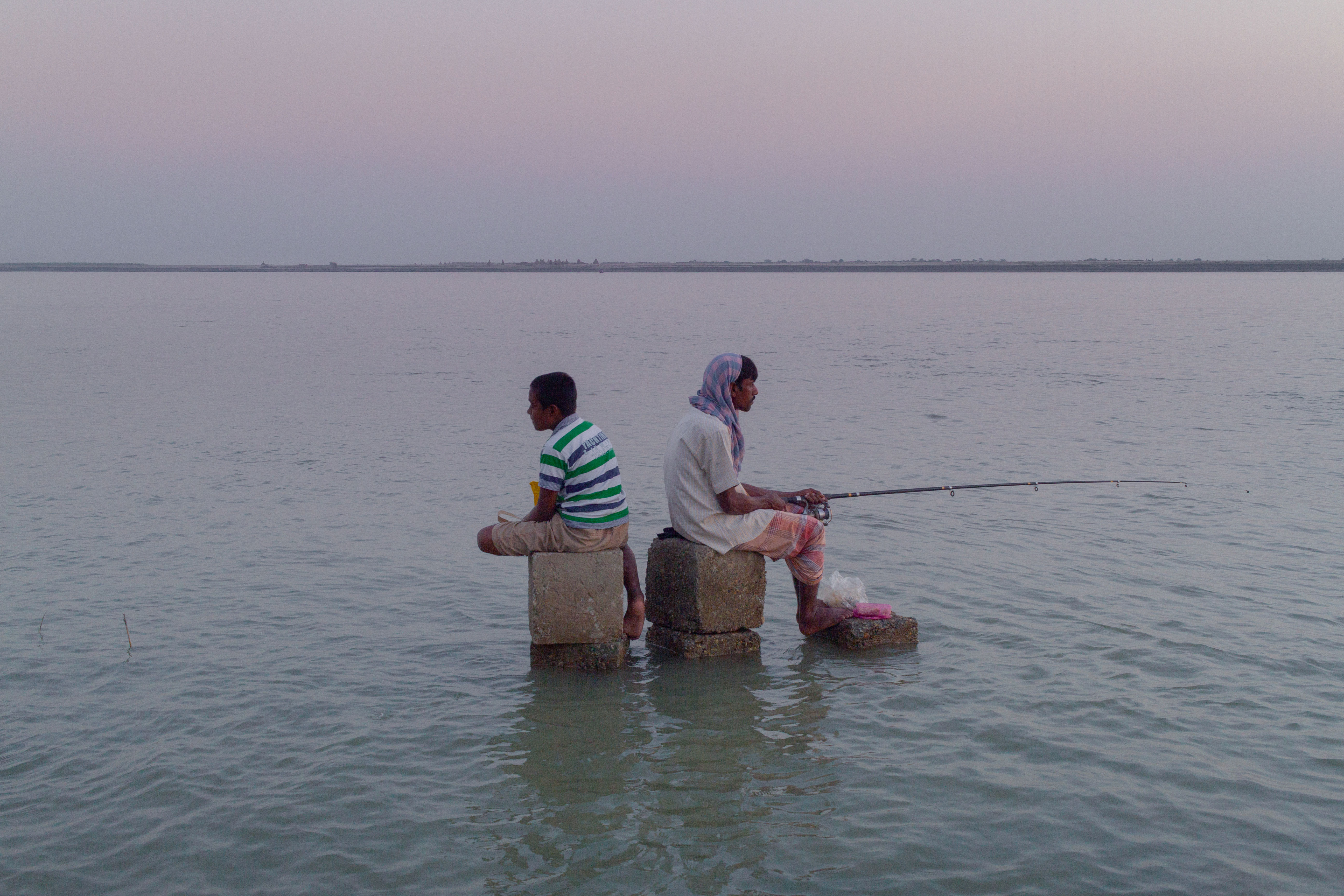 Between the ebb of the past and the flow of the future, two generations sit—one casting dreams ahead, the other lost in reflections of what once was.