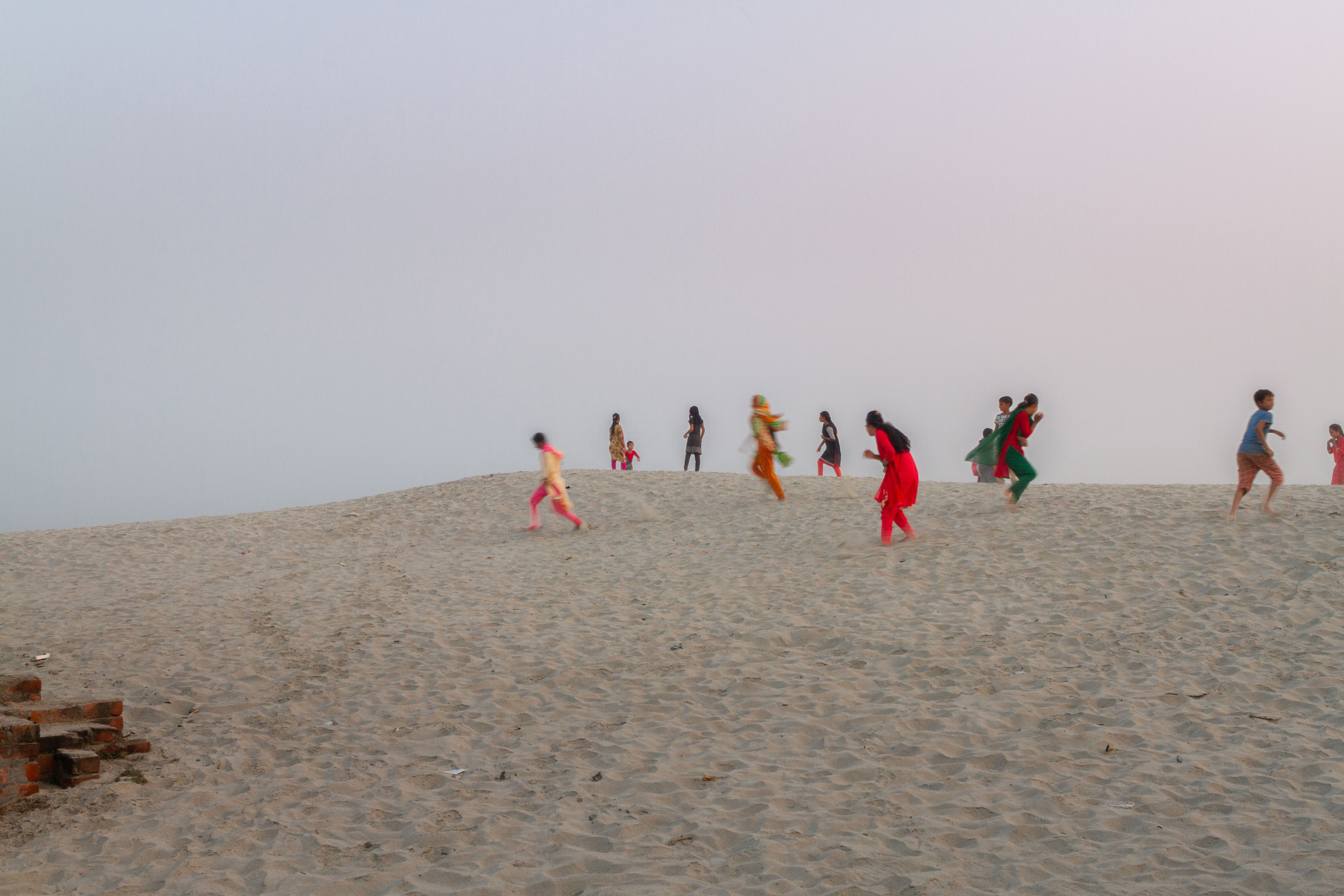 Like fleeting echoes of forgotten laughter, they run upon the dunes of time, half-dream, half-memory— caught between the past and the vanishing horizon.